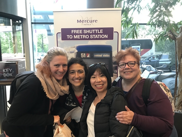 Group of women smiling in an indoor setting.