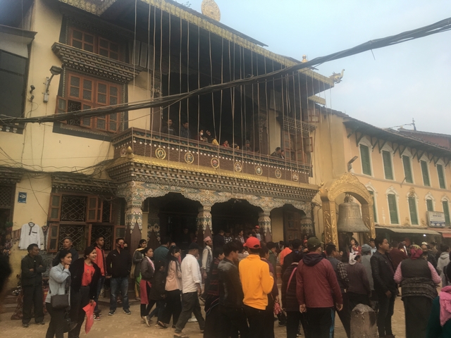       A crowd of people in front of a decorated building.
  