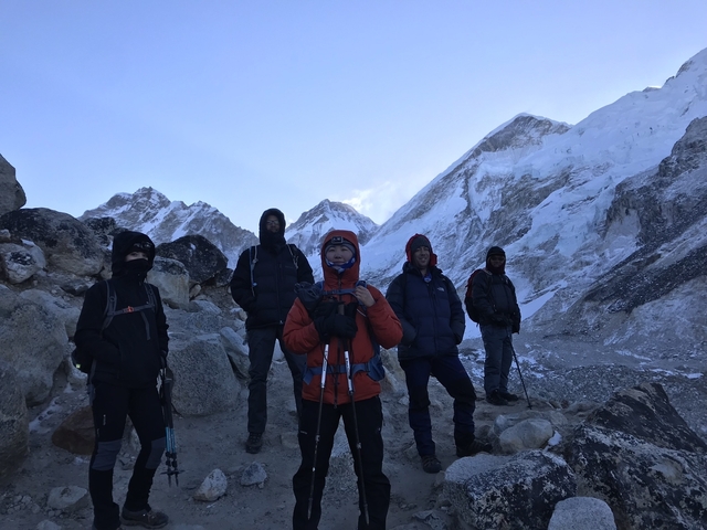       A group of trekkers posing in a snowy mountainous area.
  