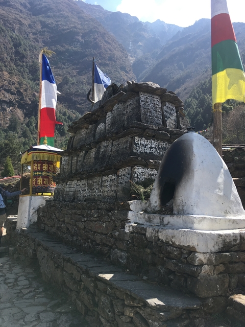       A stone mani wall with inscribed prayer stones.
  