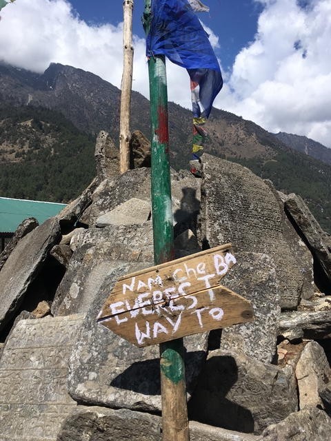       A wooden sign on a rock pile with Everest Base Camp text.
  