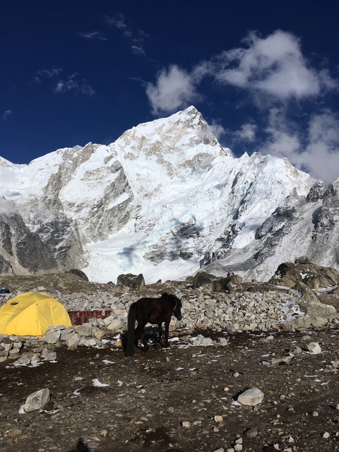       Snow-capped mountain peaks and a campsite.
  