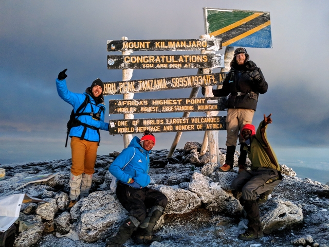       Climbers celebrating at the summit of Mount Kilimanjaro.
  