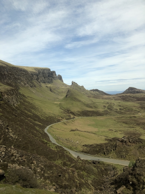 Panoramic view of rugged hills and winding road.