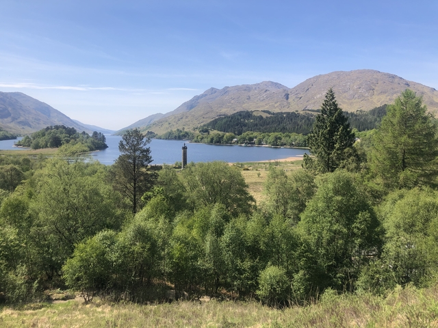Scenic view of a lake surrounded by mountains and trees.