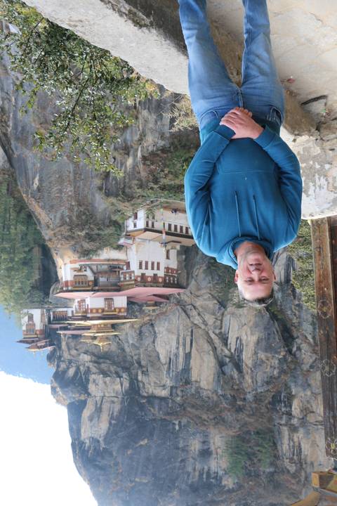       Person posing with Taktsang Monastery in the background.
  
