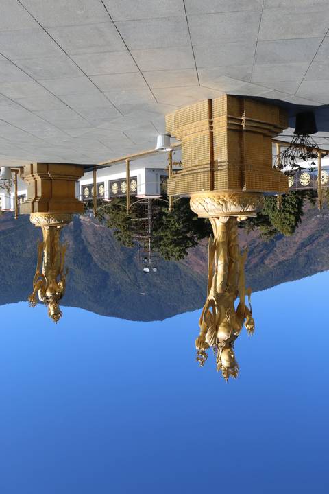       Golden statues with a mountain backdrop.
  