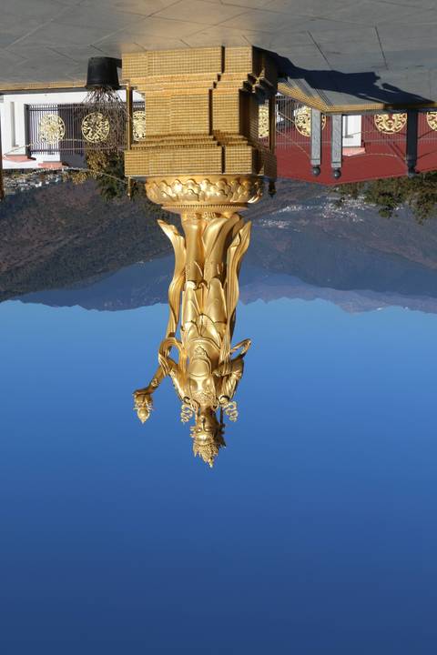       Golden statue with mountains in the background.
  