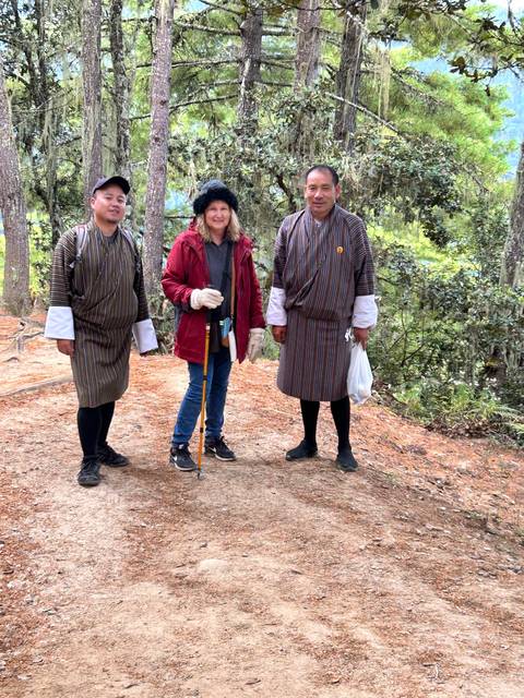       Three people standing in a forest wearing traditional attire
  