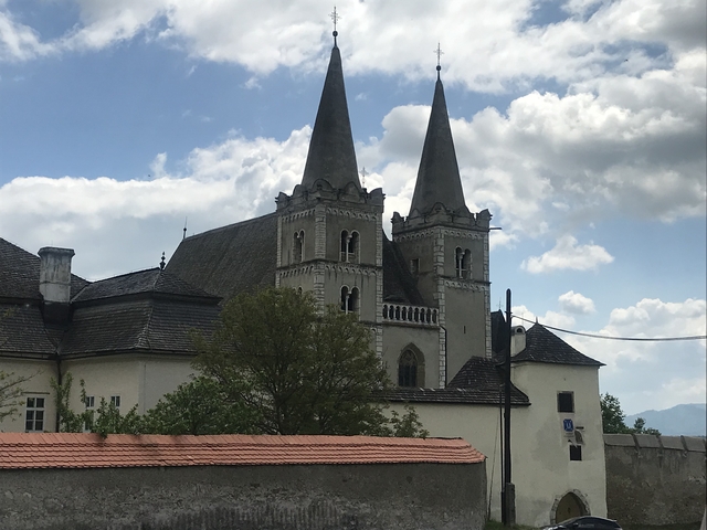 A historic church with two spires seen against a cloudy sky.