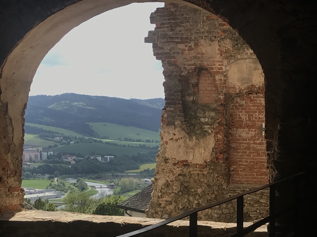 View of the countryside through a stone archway.