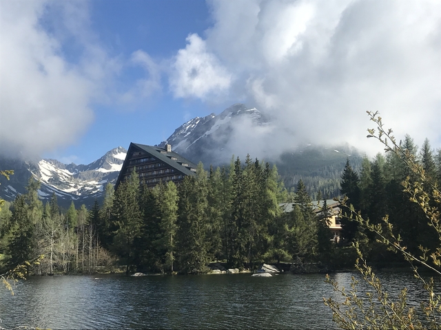 Lakeside view of mountains with a unique triangular building.