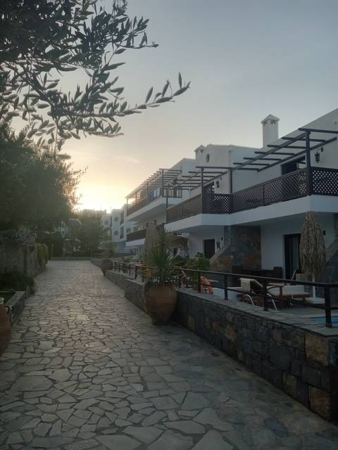      Resort area with stone paths and sunset.
  