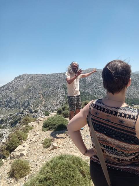       Tour guide and visitors on a mountain path.
  