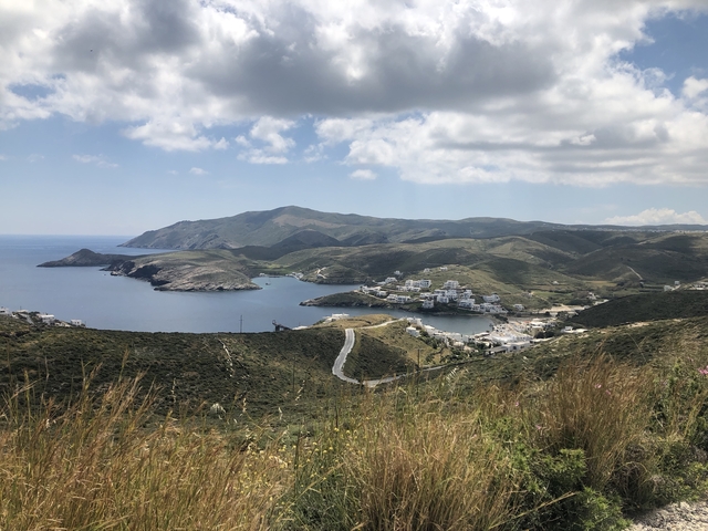 Panoramic landscape of a coastal town and surrounding hills.