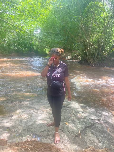       Woman standing by a small river.
  