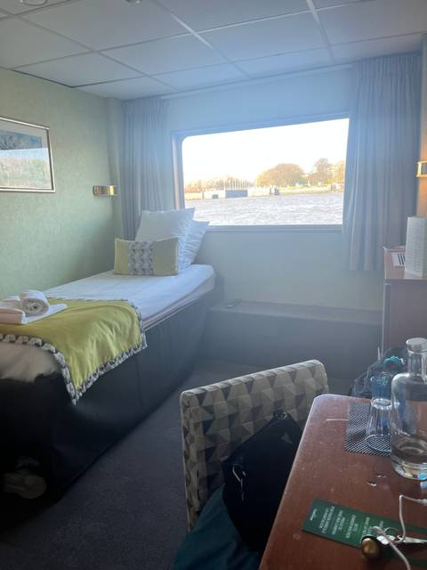 Cruise ship cabin interior with window view.