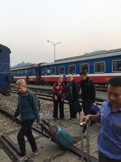 People standing on a railway platform next to a train.