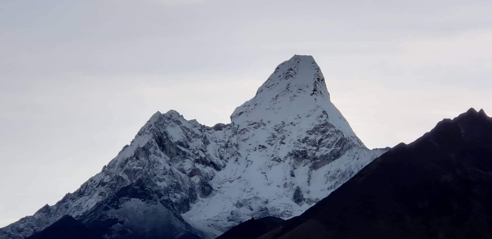 Snow-capped mountain peak against a pale sky.