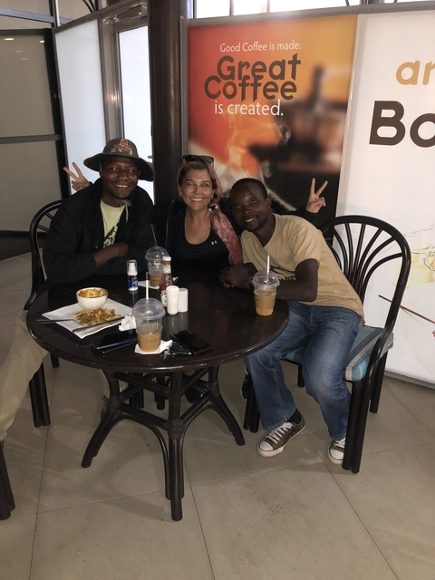 Three people sitting at a table in a cafe.