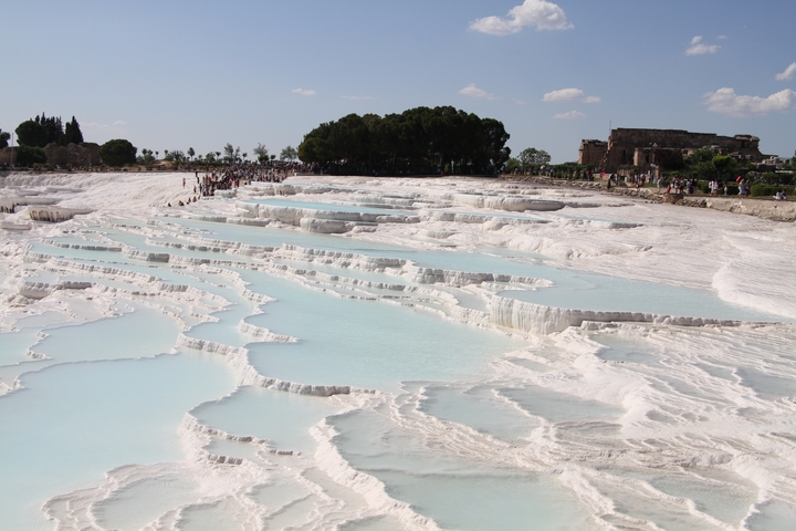 White travertine terraces filled with turquoise water.