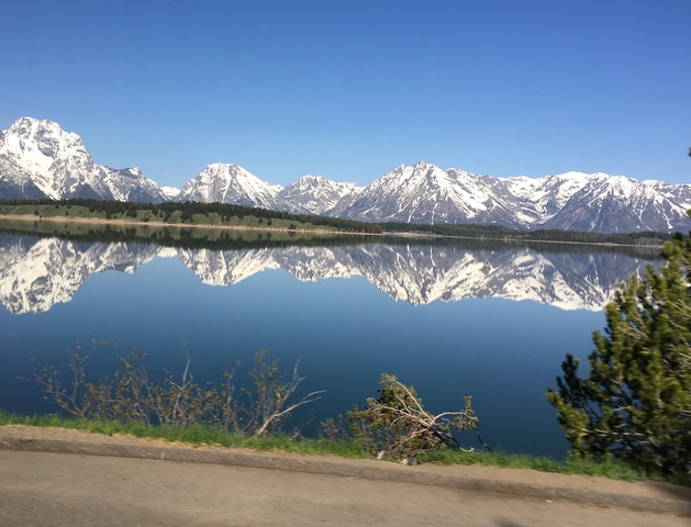 Snow-capped mountains reflecting in a calm lake.