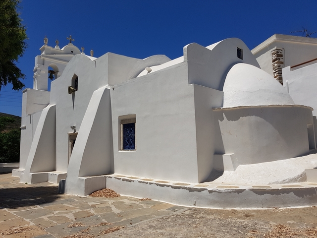 Whitewashed church with domed roof against a blue sky.