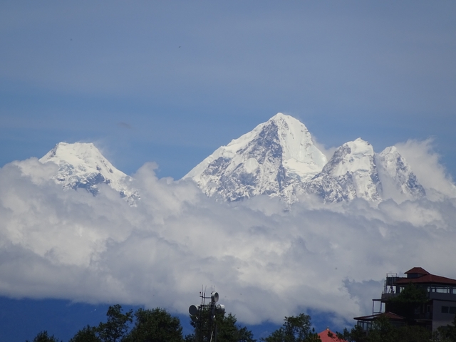 Snow-capped mountains appearing above the clouds in the distance.