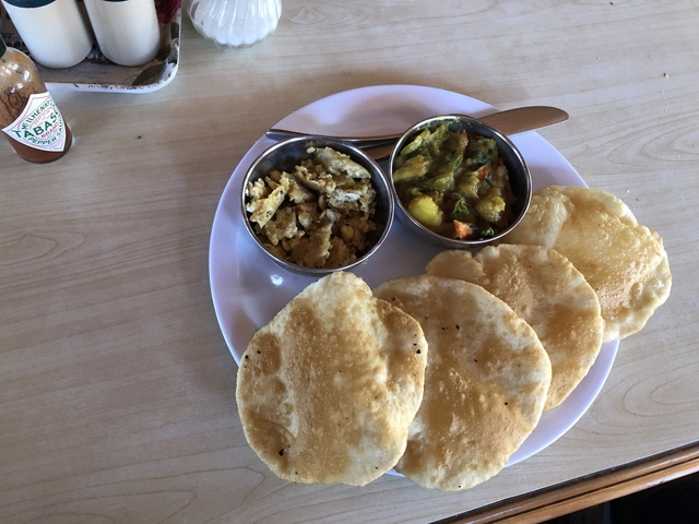 Traditional Nepali meal with fried bread and curries.