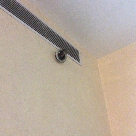       Broken ventilation duct on a blank wall.
  