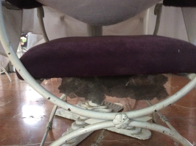Dusty underside of a chair with curled foams.