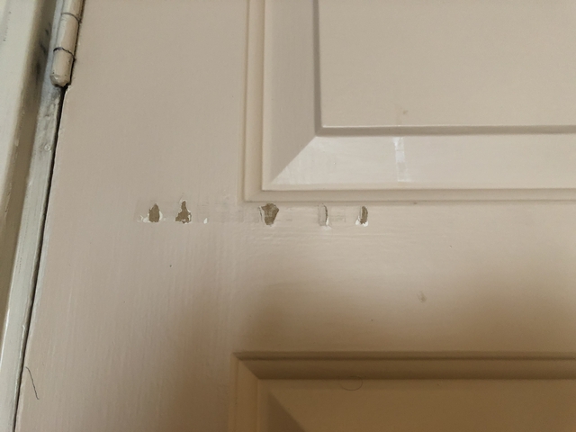 Close-up of a door with scratched paint.