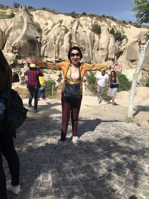       Woman posing with rock formations in the background.
  