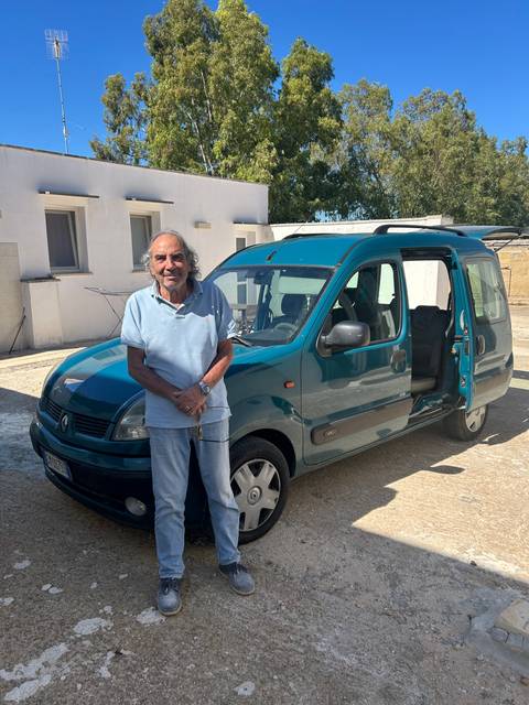       Person standing next to a van on a sunny day.
  