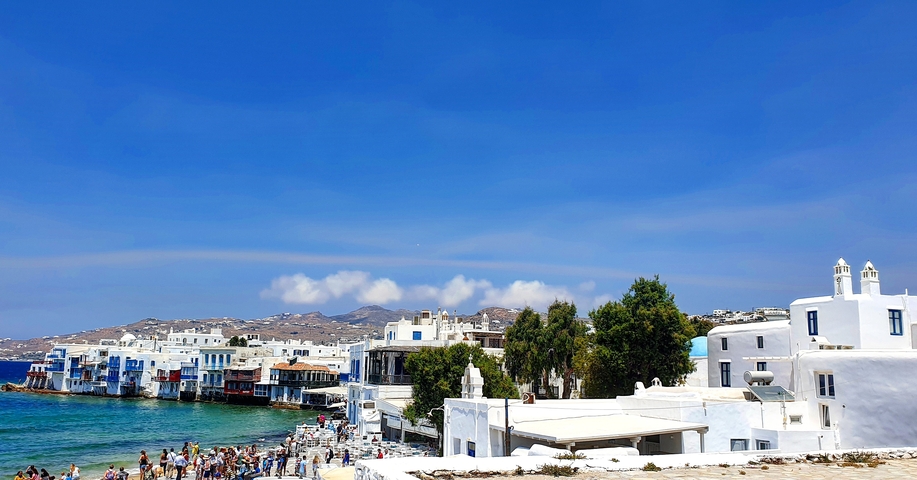 Picturesque view of whitewashed buildings by the sea in Mykonos.