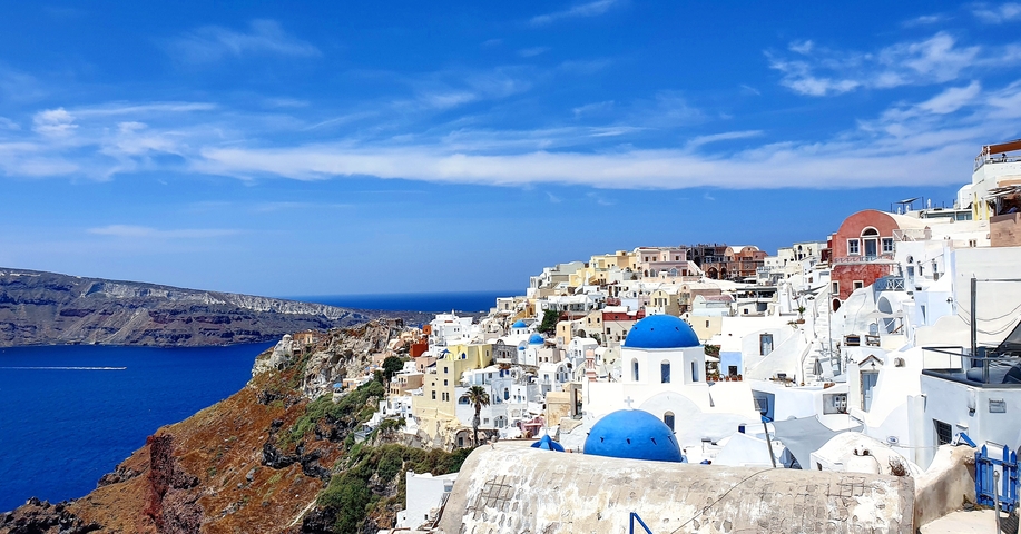 Iconic view of Santorini with blue domed churches and sea.
