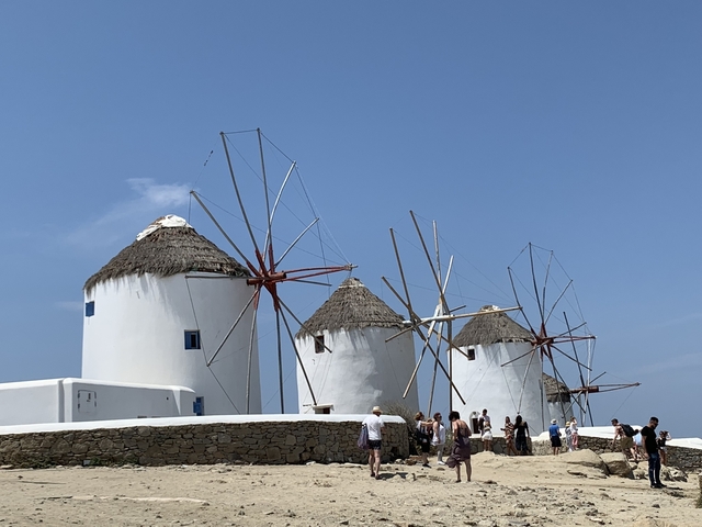       Famous windmills with tourists in Mykonos.
  