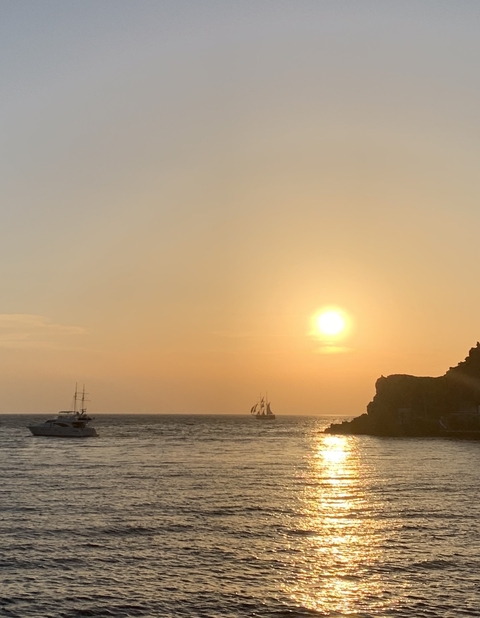 Silhouette of a ship against a vibrant sunset sky.