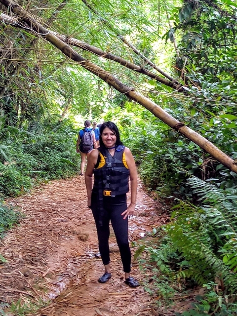       Woman in a forested path wearing a life vest.
  