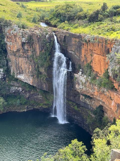       Waterfall cascading off a cliff in a tropical setting.
  