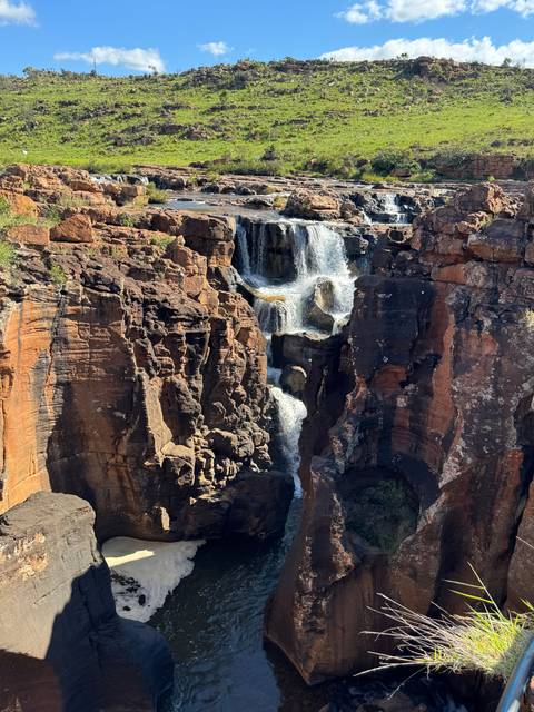       Waterfall flowing over rocks into a pool.
  