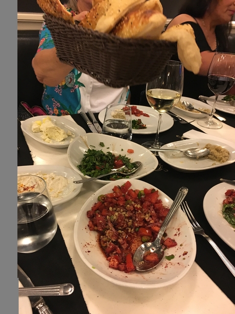 Table with various plates of food and drinks.