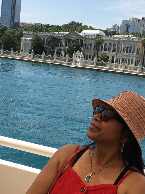 Person wearing a hat near a body of water.