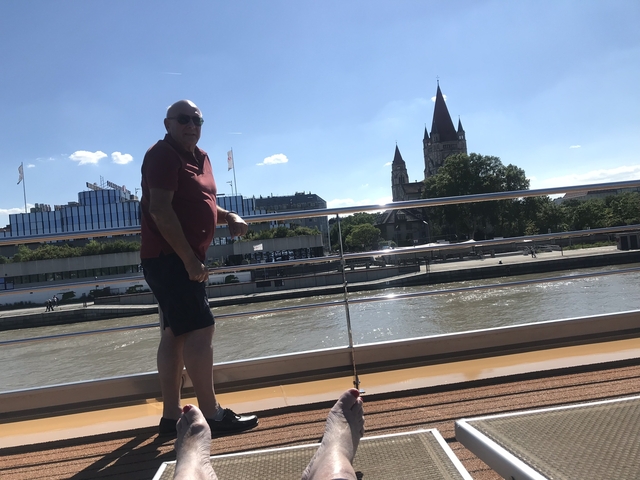 A person standing on a boat with a city skyline in the background.