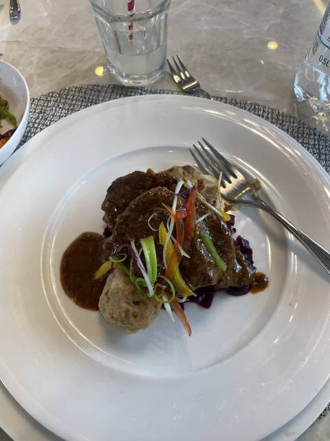Upside-down plate of gourmet food with cutlery.