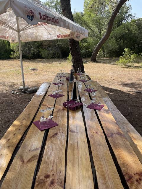 Upside-down outdoor wooden picnic table with glasses and napkins.