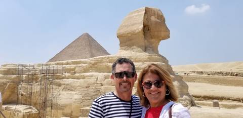       A couple in front of the Sphinx and a pyramid.
  