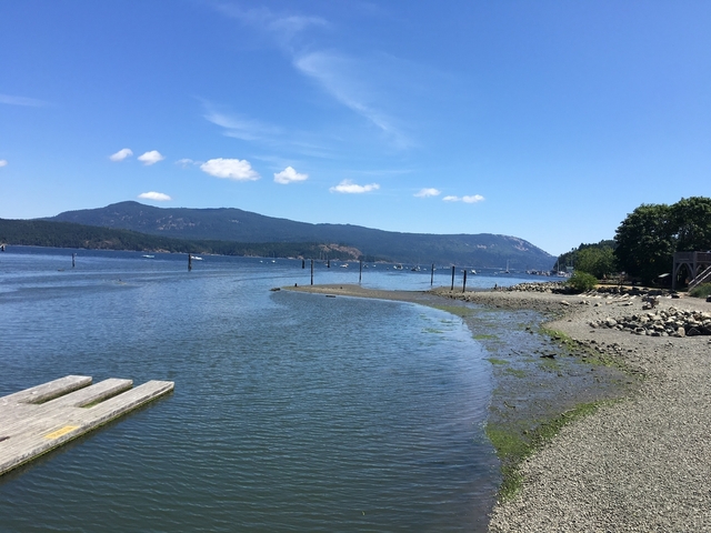 A coastal view with a shoreline and distant mountains.