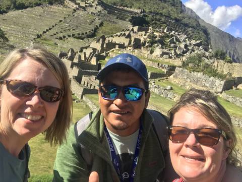 A group of people upside down with Incan ruins in the background.