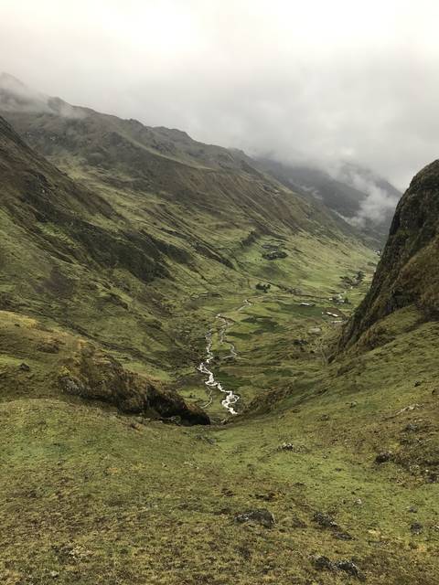 Aerial view of a winding river through a green valley.